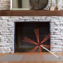 VEVOR chimney sweep kit in front of a brick fireplace and wooden mantel.