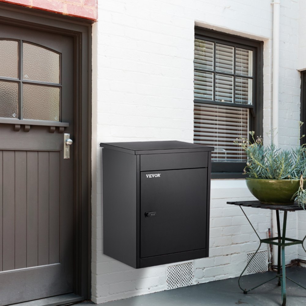 black VEVOR parcel drop box mounted on a white brick wall next to a brown door.