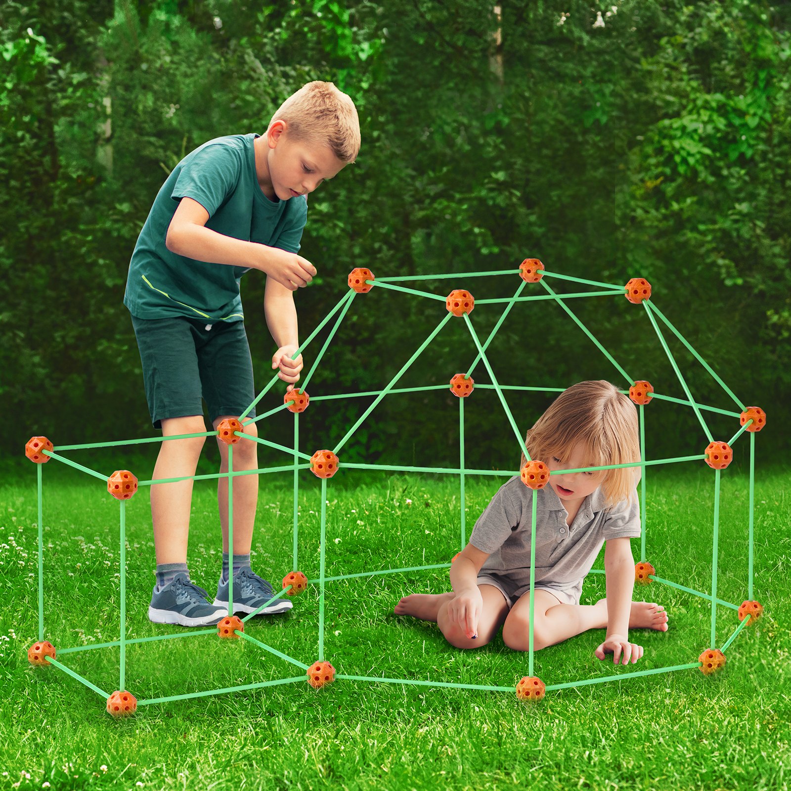 kids building a fun structure on grass using VEVOR tent fort kit, surrounded by greenery.