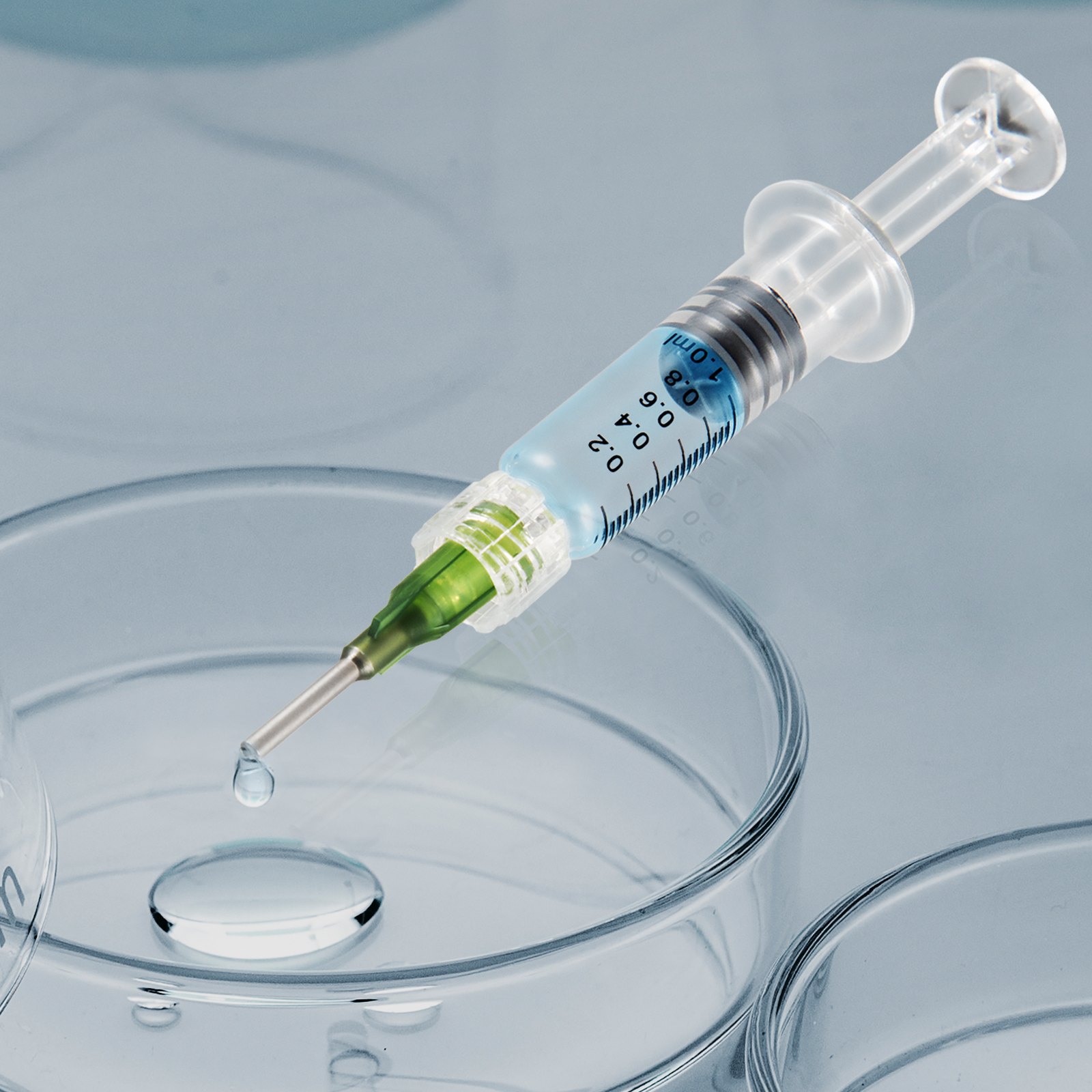 VEVOR glass syringe with blue liquid and green tip, dropping into a petri dish.