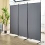 VEVOR room divider in a modern living space with gray panels, black frames, indoor plant, and light wood flooring.
