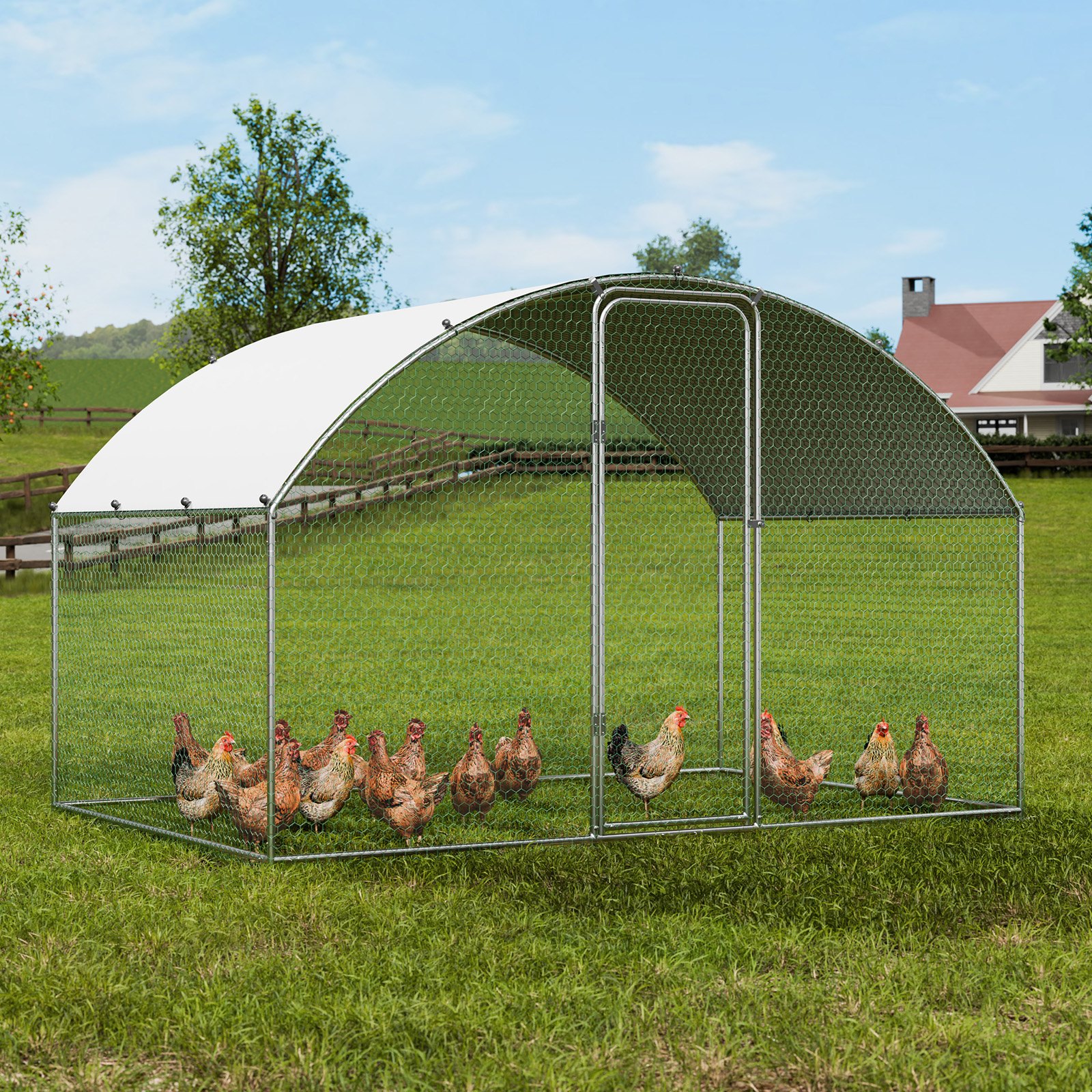 VEVOR chicken coop with multiple chickens in a lush green field near a farm house under a clear blue sky.