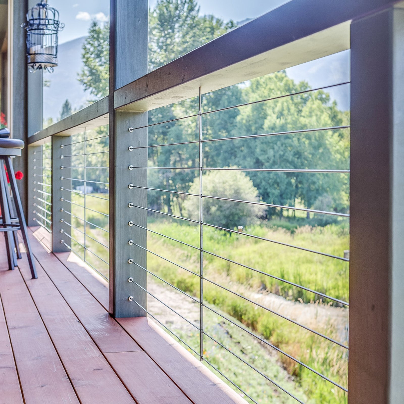 outdoor deck with view of trees and VEVOR stainless steel cable railing sleeves in a scenic landscape.