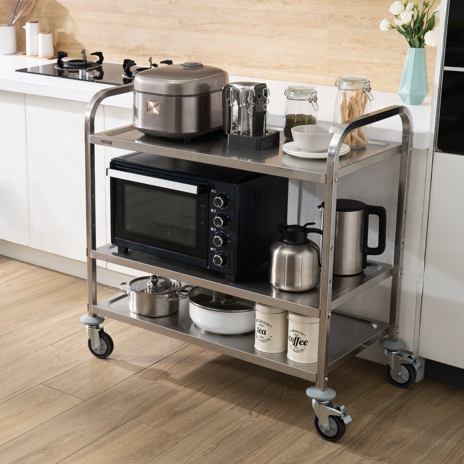 VEVOR kitchen utility cart with kitchen appliances including microwave, rice cooker, and jars on a wood floor.