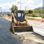 bulldozer flattening dirt over VEVOR geotextile fabric on a sunny construction site.