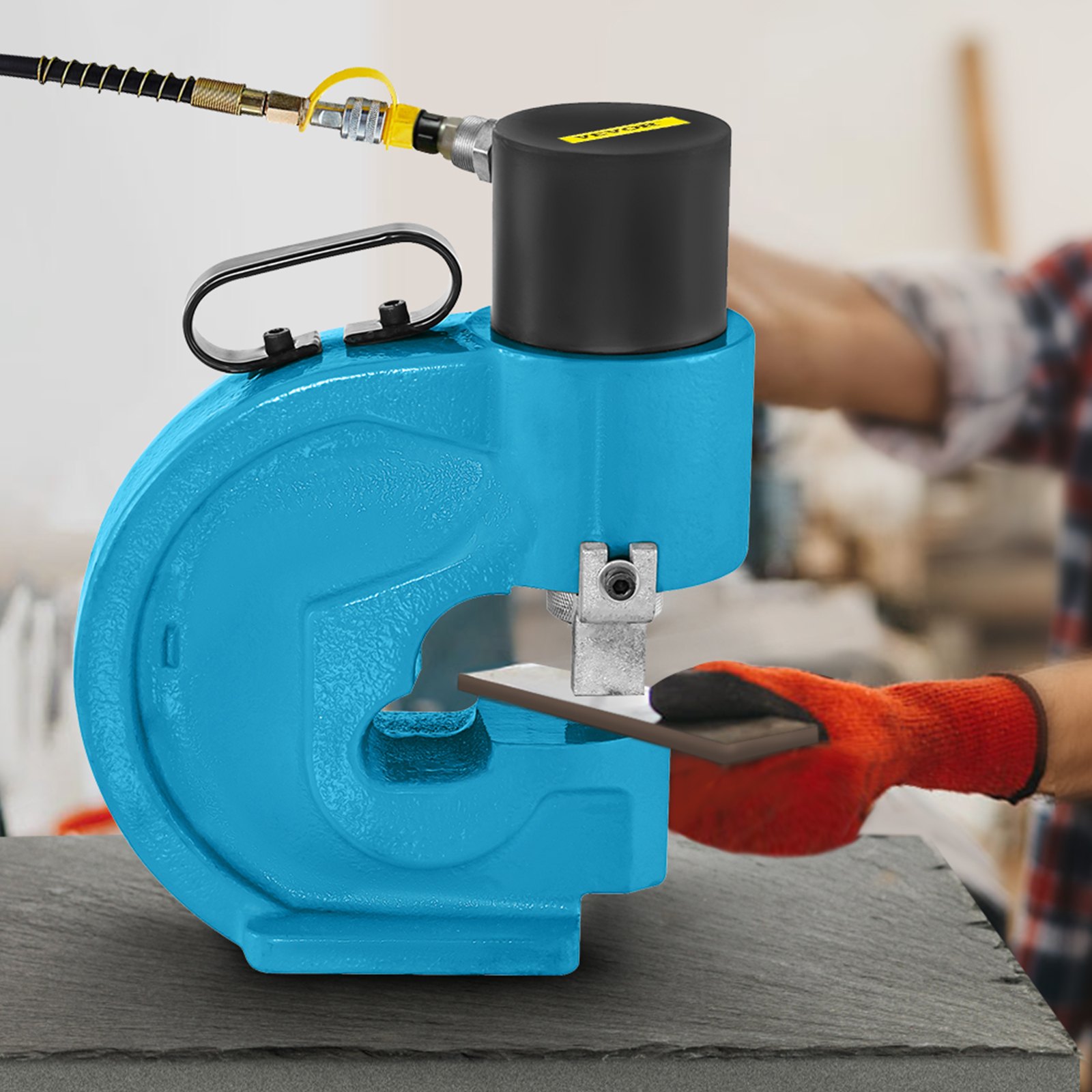 VEVOR hydraulic hole punching tool punching metal sheet with worker&#039;s gloved hands.