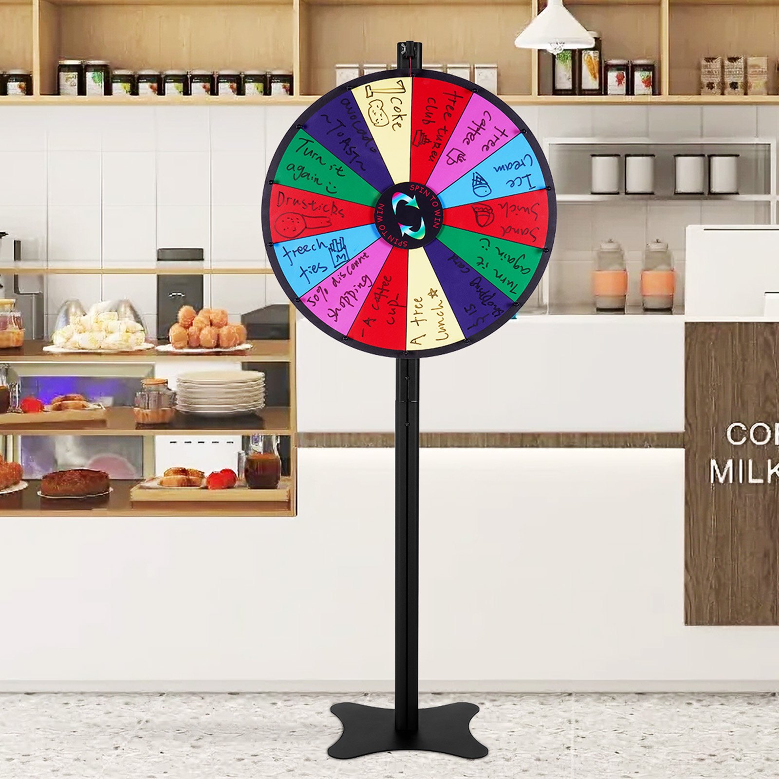 VEVOR spinning prize wheel in a café setting with bakery items and jars on shelves in the background.