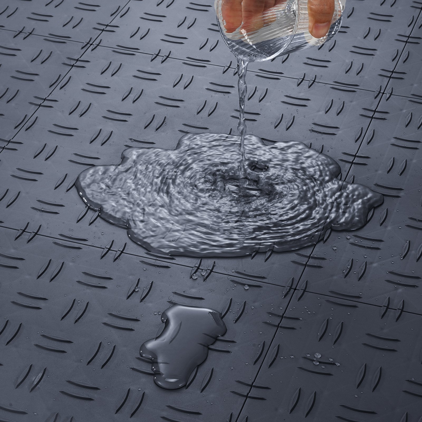 hand pouring water on VEVOR garage tiles, water-resistant with textured, interlocking design.