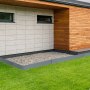 modern home exterior with VEVOR steel landscape edging, stone bed, and lush green lawn.