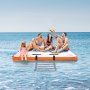 group of people relaxing on a VEVOR inflatable floating dock in the ocean.