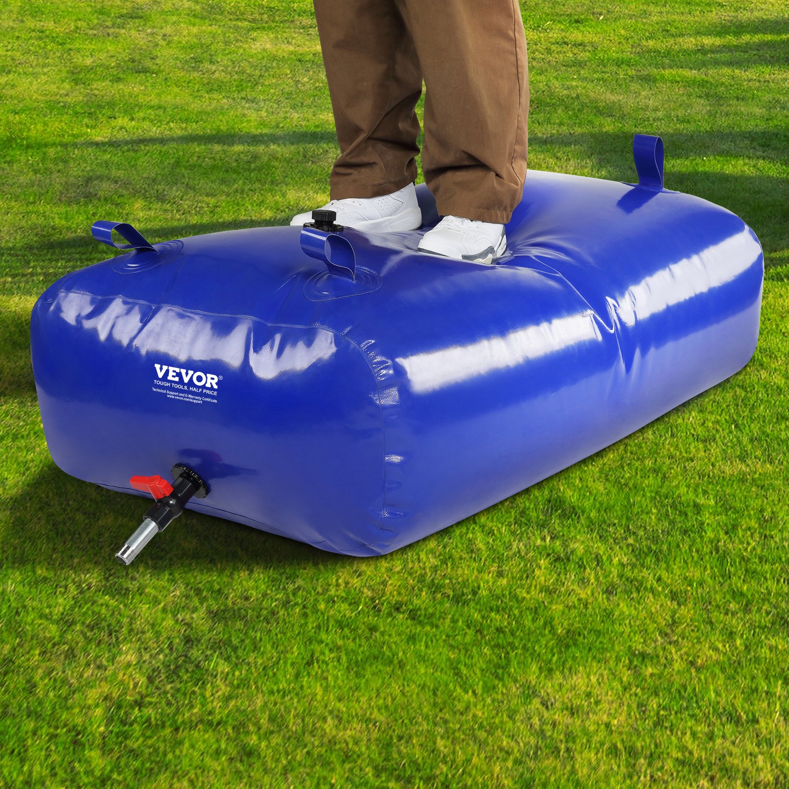 person standing on a VEVOR water tank in a grassy field.