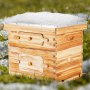 VEVOR bee hive starter kit in a grassy field, wooden structure with a snowy top.
