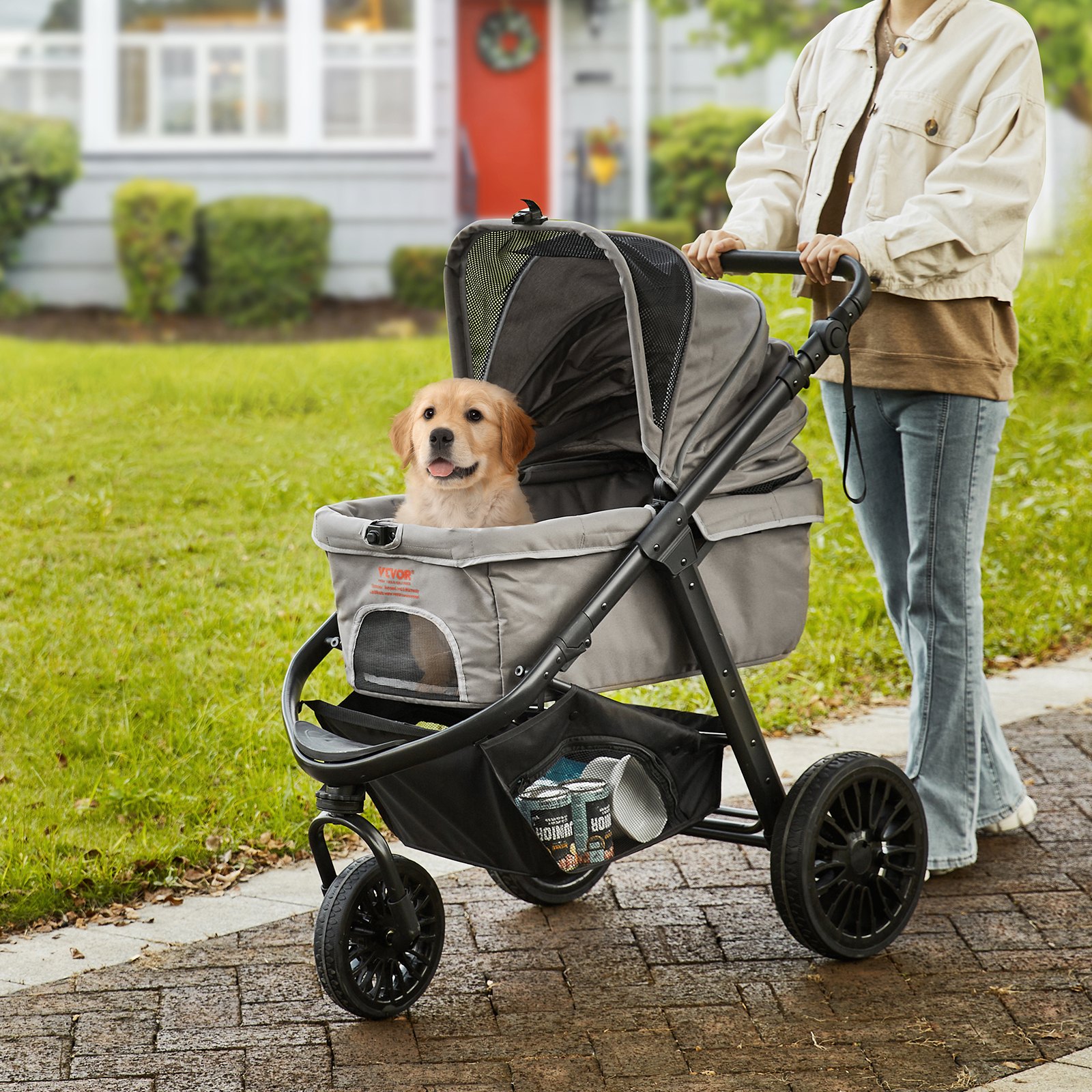 walking a dog in a VEVOR pet stroller on a sunny day with a cozy neighborhood backdrop.