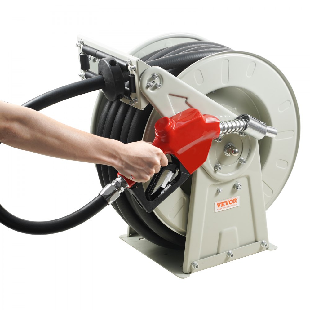 person holding a red fuel nozzle of a mounted VEVOR fuel hose reel.