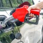 car being refueled with a red nozzle, highlighting the VEVOR fuel hose reel effectiveness.