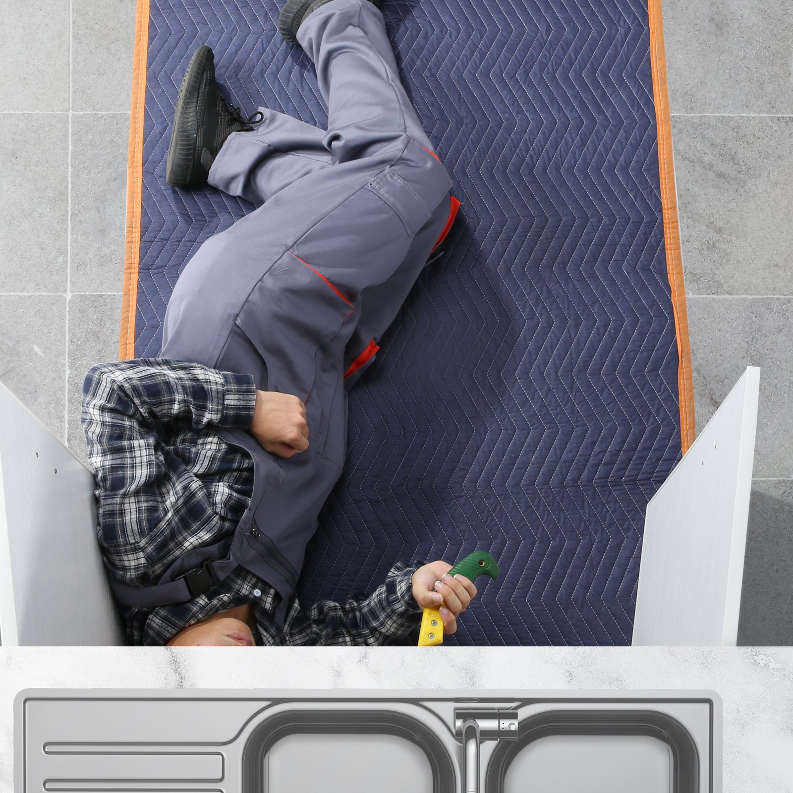 person lying on blue VEVOR moving blankets on a tiled floor, wearing gray overalls and holding a tool.
