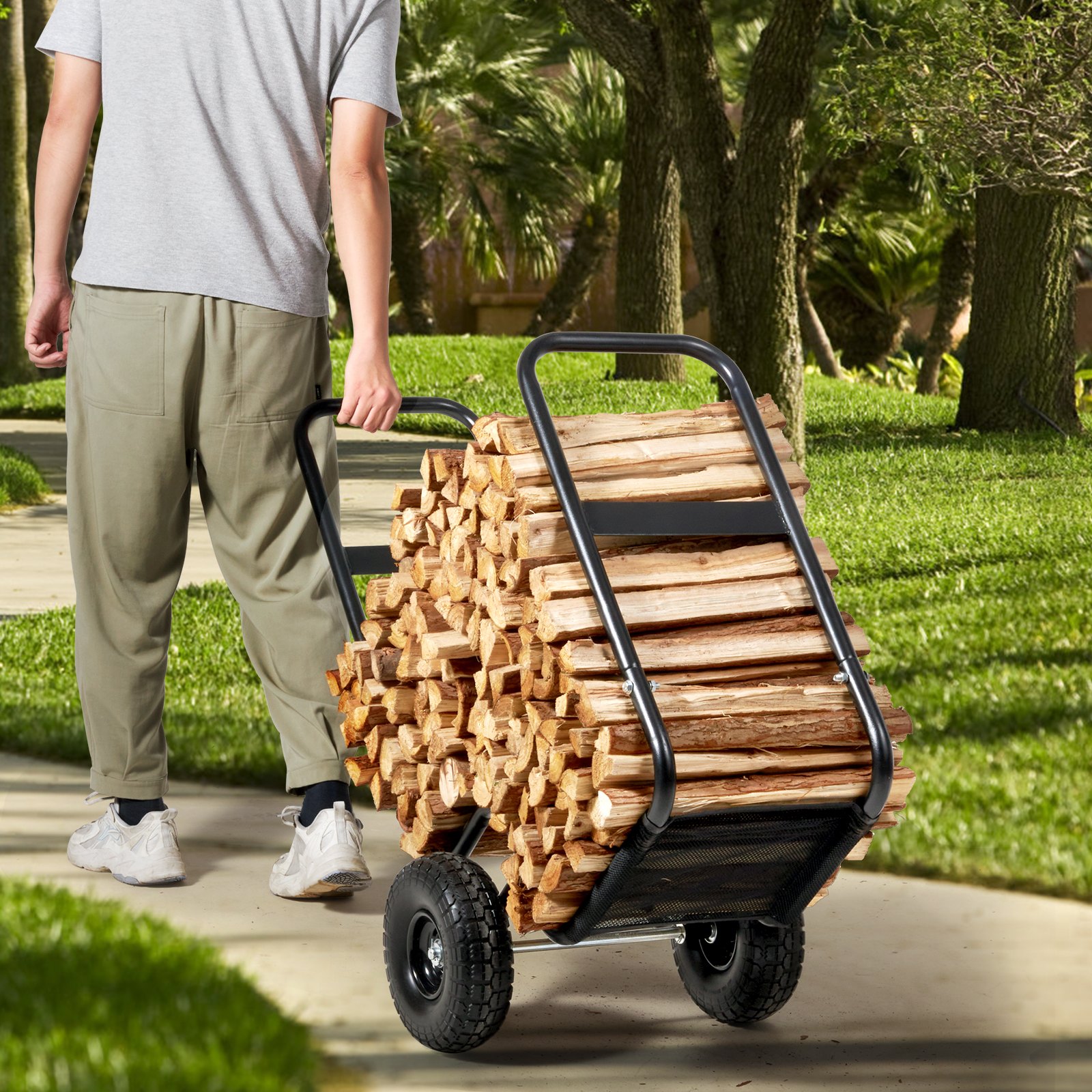 man transporting firewood using VEVOR firewood log cart in a green park.
