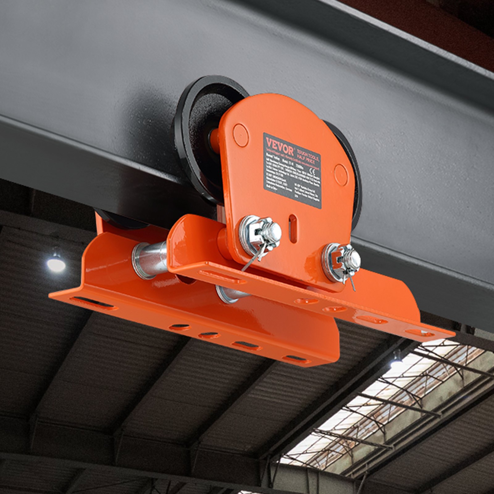 orange VEVOR electric hoist trolley mounted on a steel beam inside an industrial warehouse.