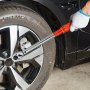 hand using a VEVOR torque wrench on a car wheel with silver alloy rims and continental mc6 tire.