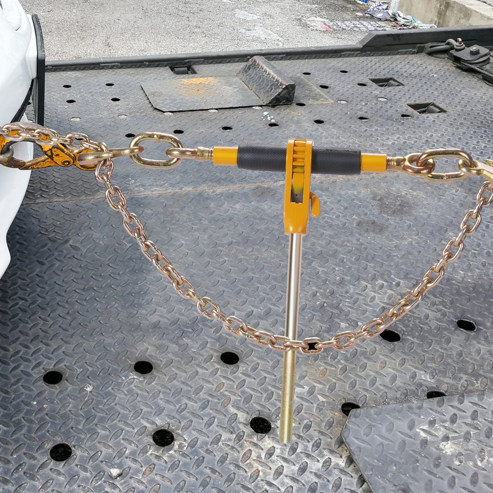 VEVOR ratchet chain binder securing a load on a metal surface with attached chains and hooks.