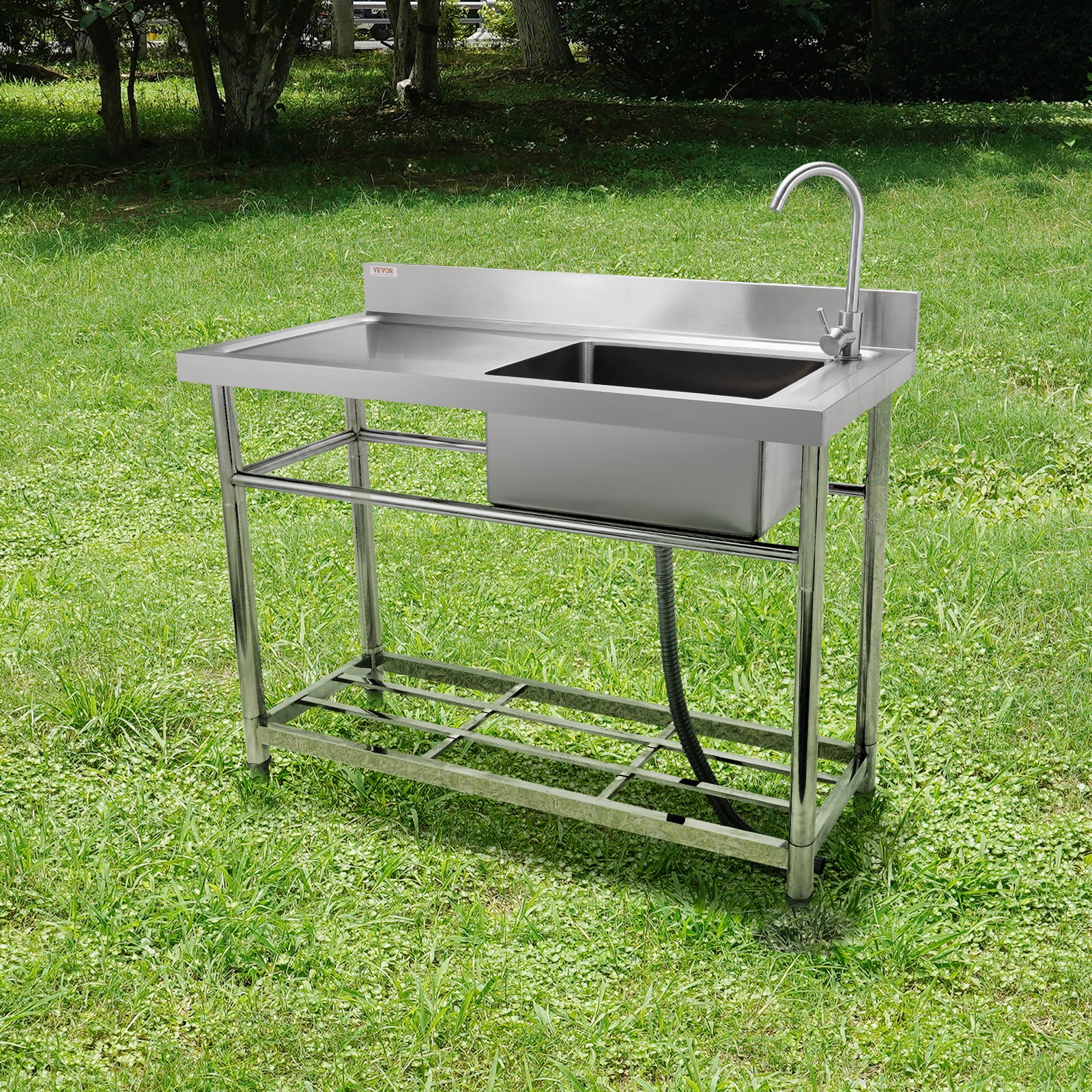 VEVOR commercial kitchen sink in a grassy outdoor area with stainless steel construction and faucet.