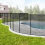 VEVOR pool fence surrounding a garden swimming pool with paved stone tiles and lawn in the background.