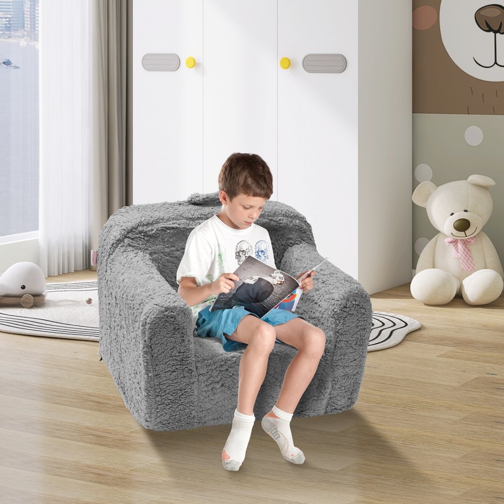 child reading on a cozy grey VEVOR kids armchair in a bright, playful room with a teddy bear in the background.