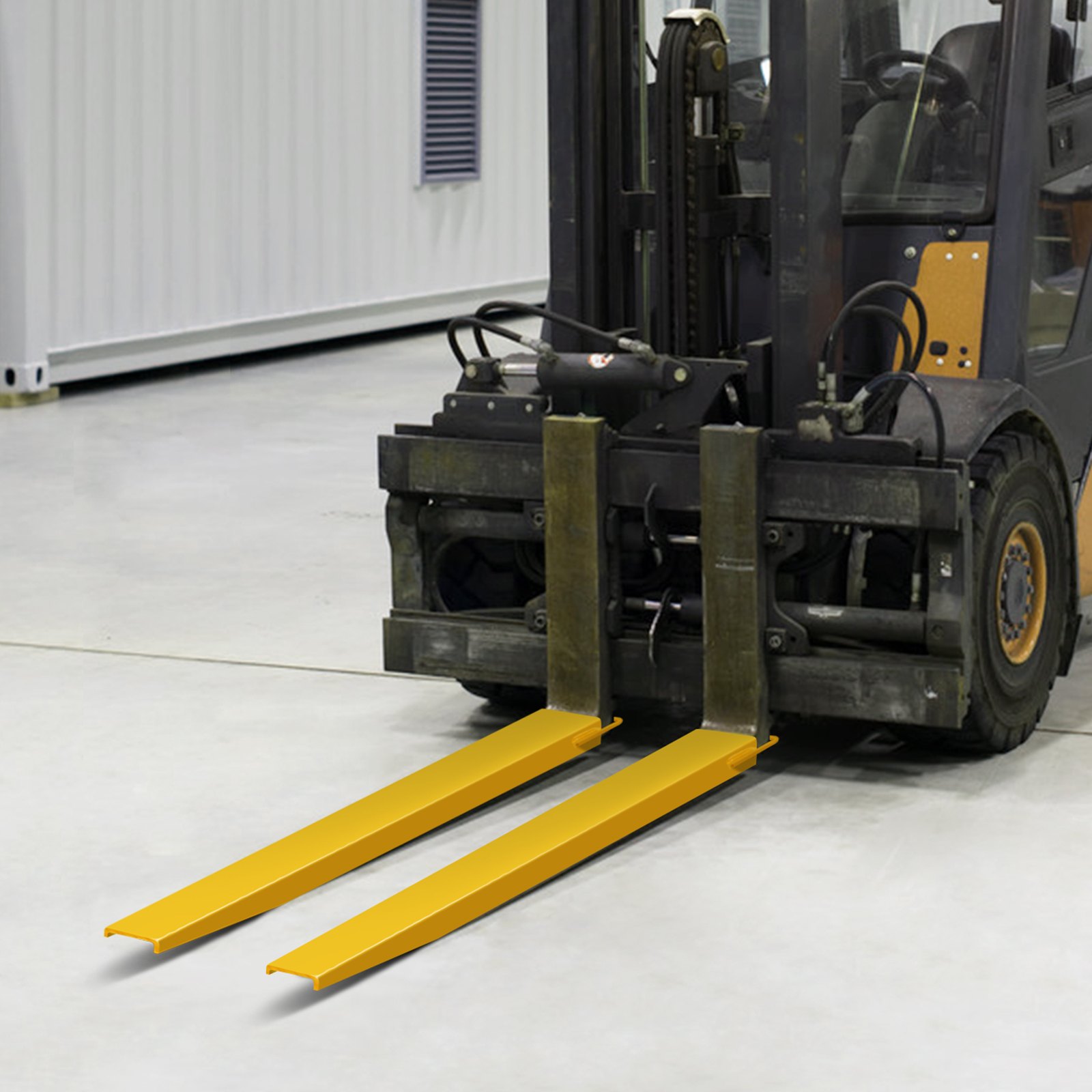 forklift with VEVOR pallet fork extensions on a concrete floor in a warehouse.