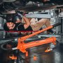 mechanic using VEVOR porta power kit under a car with a hydraulic body frame repair tool and accessories