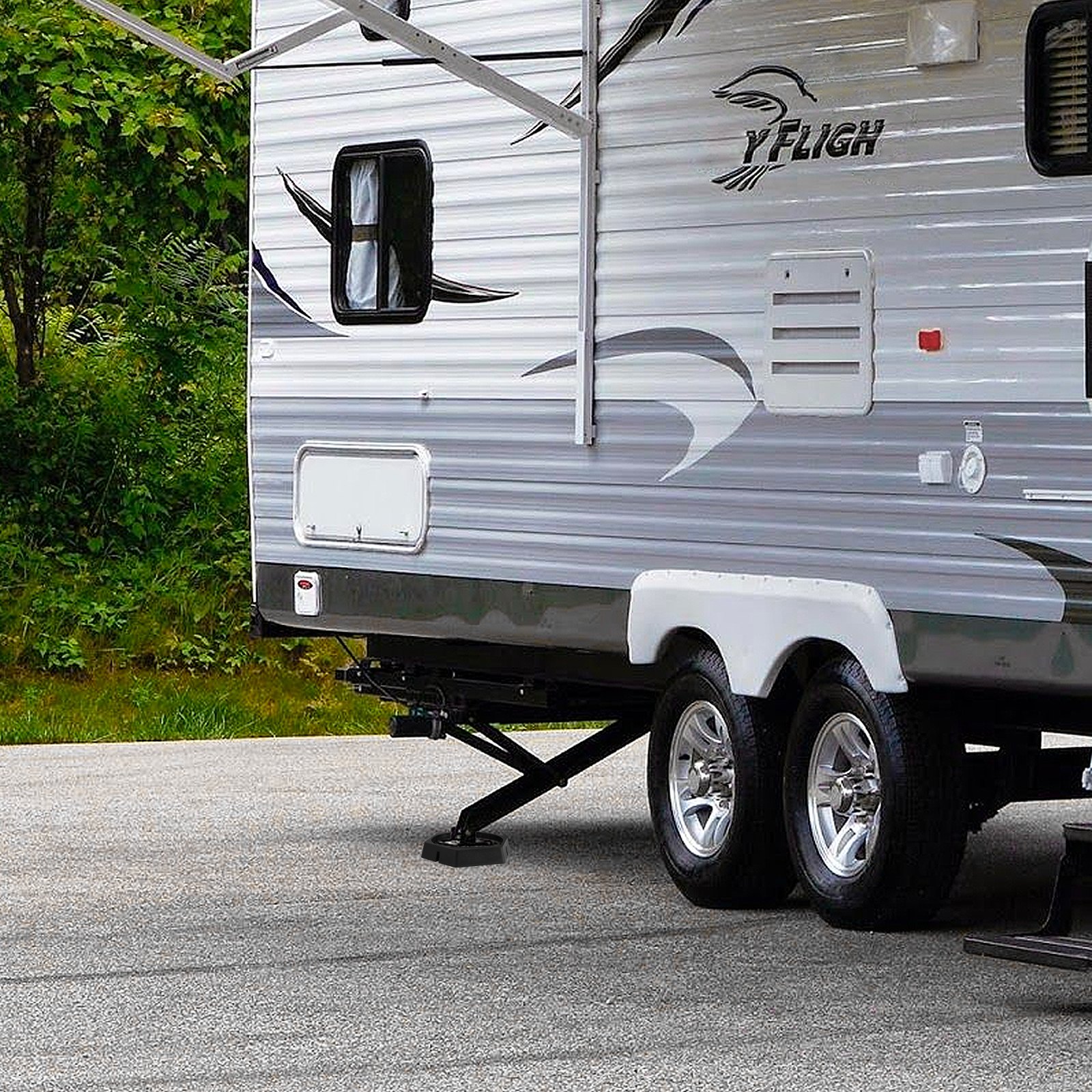 VEVOR rv leveling pads under a trailer&#039;s stabilizer with lush greenery background and clear sky.