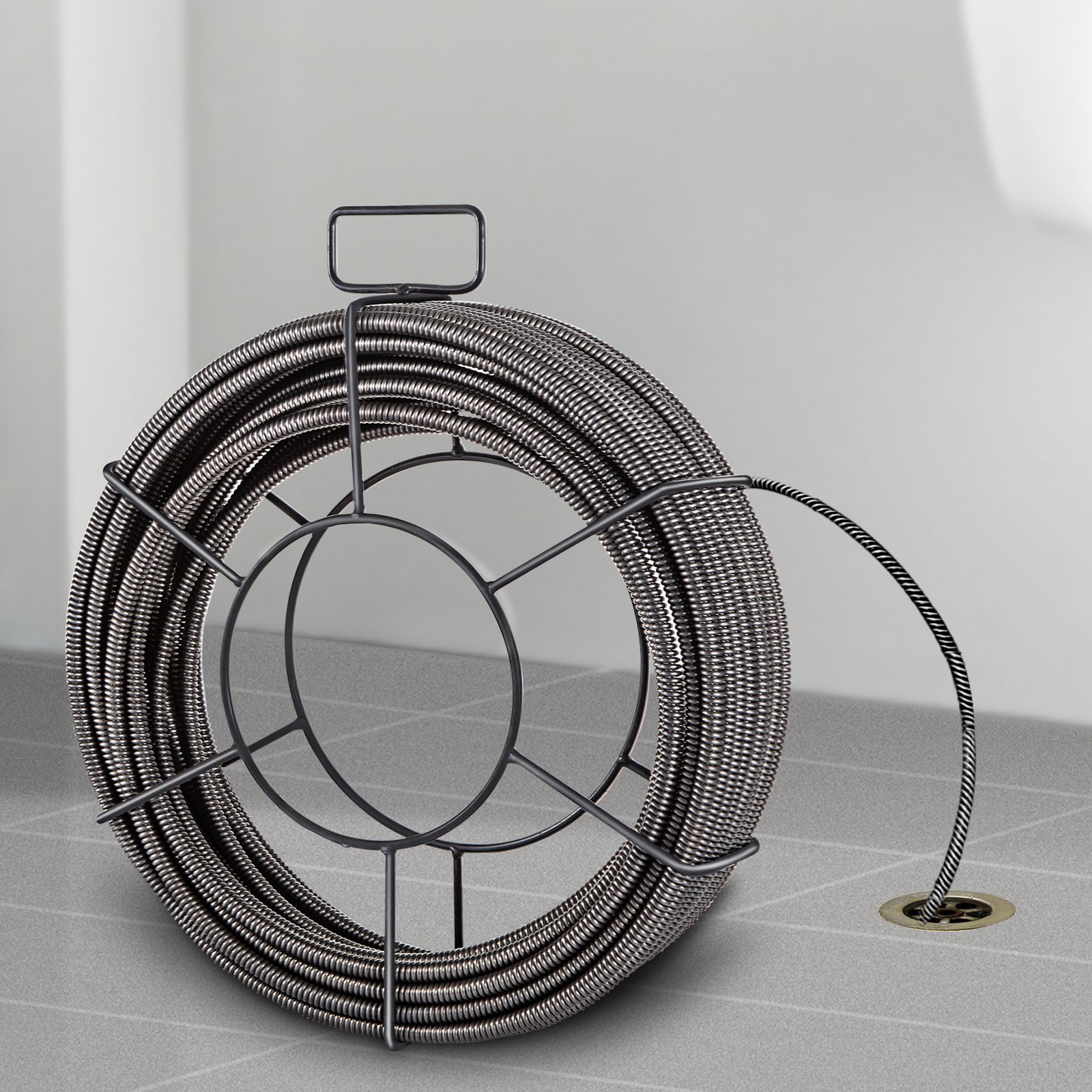 VEVOR drain cleaning cable coiled on the floor with its end inserted in a drain.