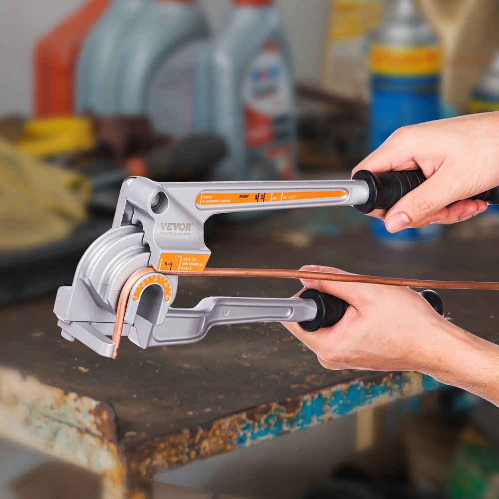 hands using a VEVOR pipe tube bender on a copper pipe in a workshop.