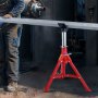 worker assembling metal pipe using VEVOR pipe stand in an industrial setting.