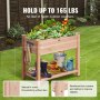 VEVOR garden bed with lush green plants, sturdy wood frame, and storage shelf holding tools and boots.