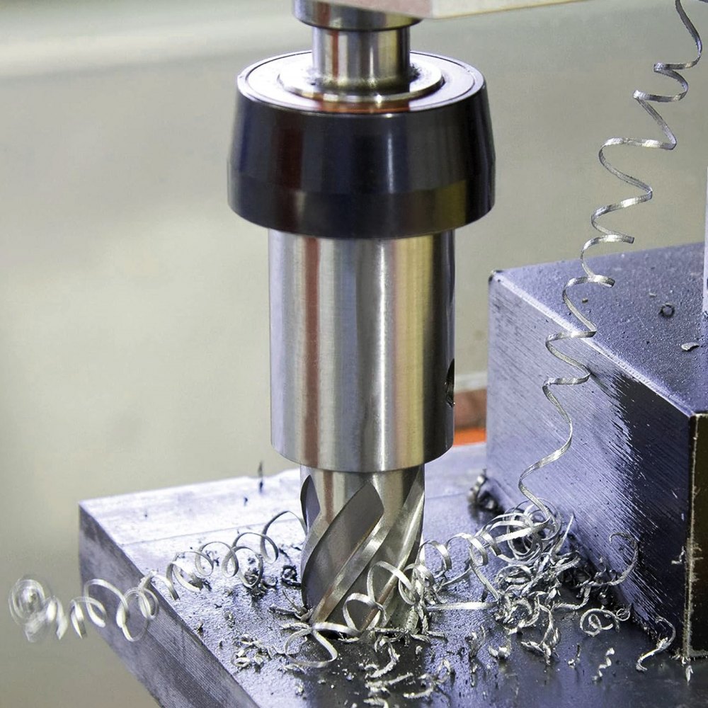 annular cutter drilling through steel with metal shavings around, showcasing VEVOR annular cutter set.