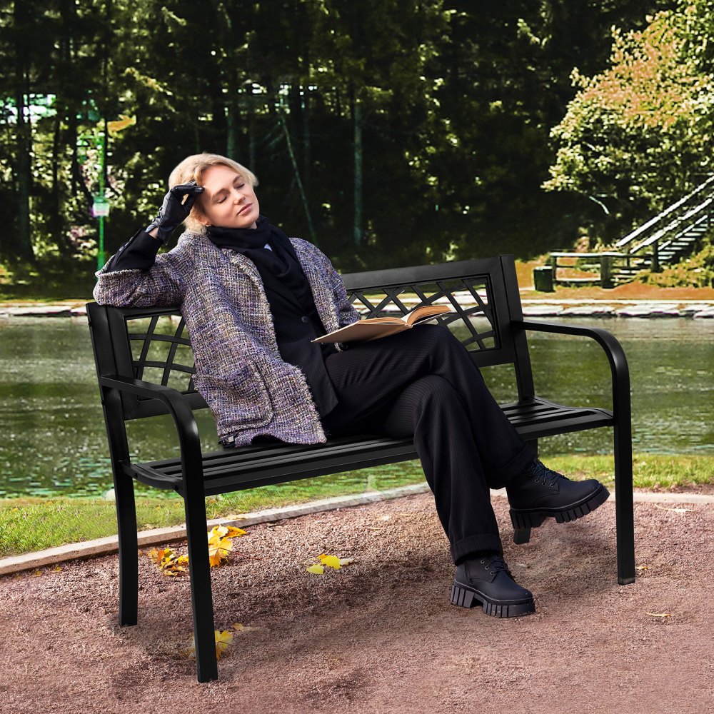 person relaxing on a VEVOR outdoor bench by a pond, surrounded by lush greenery in a serene park setting.