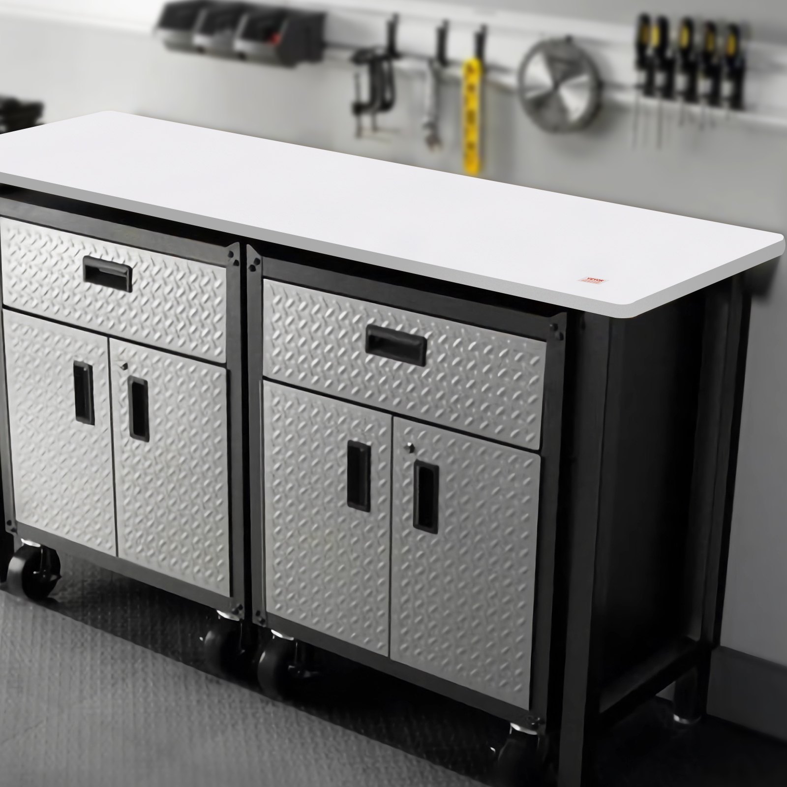 VEVOR standing desk countertop with diamond plate cabinets and tools on wall in background.