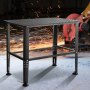 VEVOR welding table with sparks flying from an angle grinder in the background.