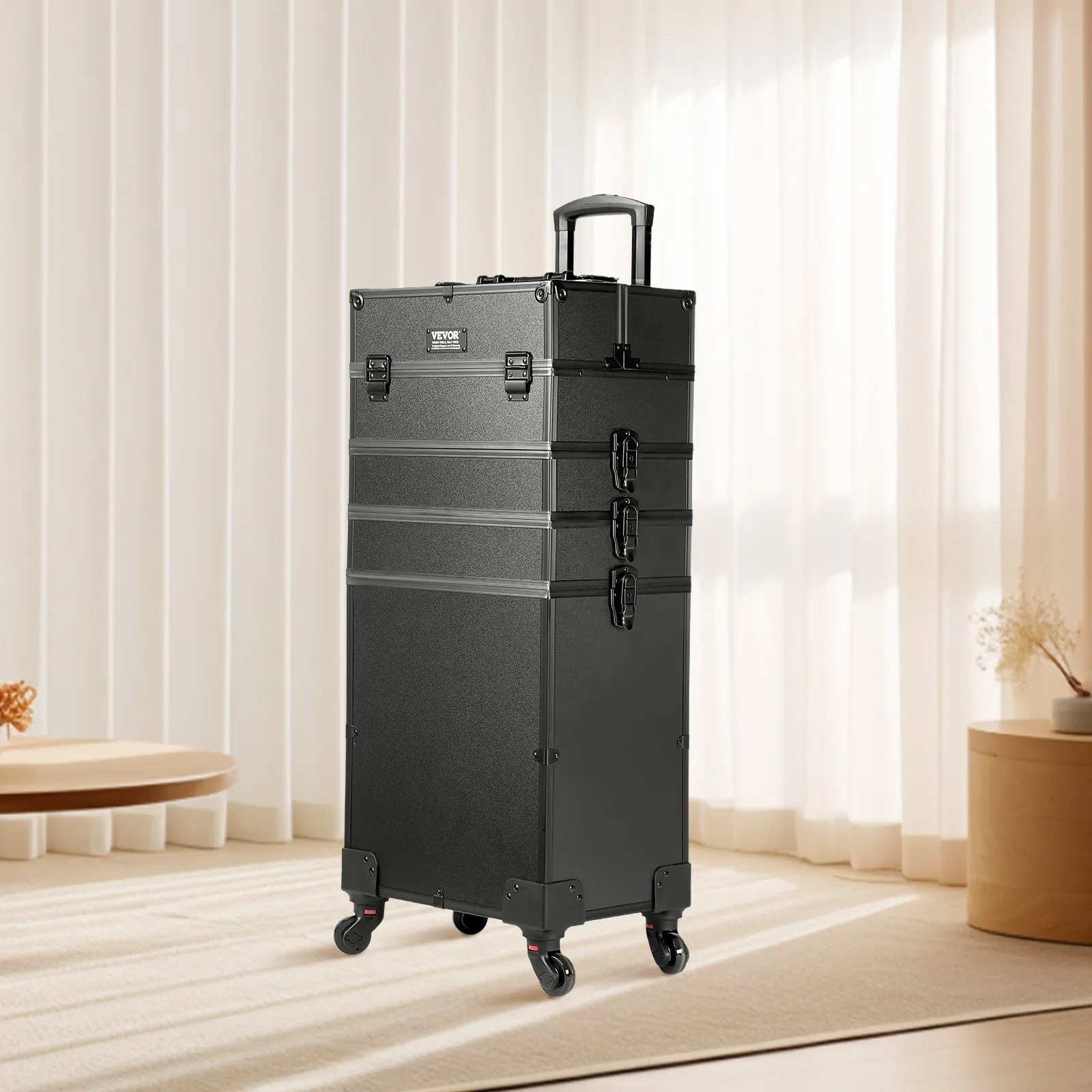 black VEVOR makeup train case with wheels and handle, standing in a bright room with beige curtains.