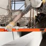 worker using VEVOR magnetic torpedo level on construction site with gloves and tools, focusing on precision.