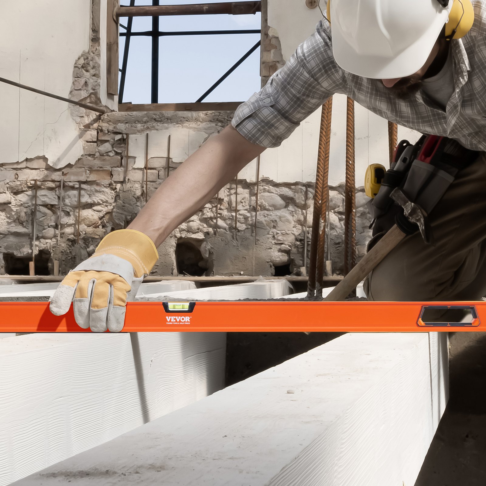 worker using VEVOR magnetic torpedo level on construction site with gloves and tools, focusing on precision.