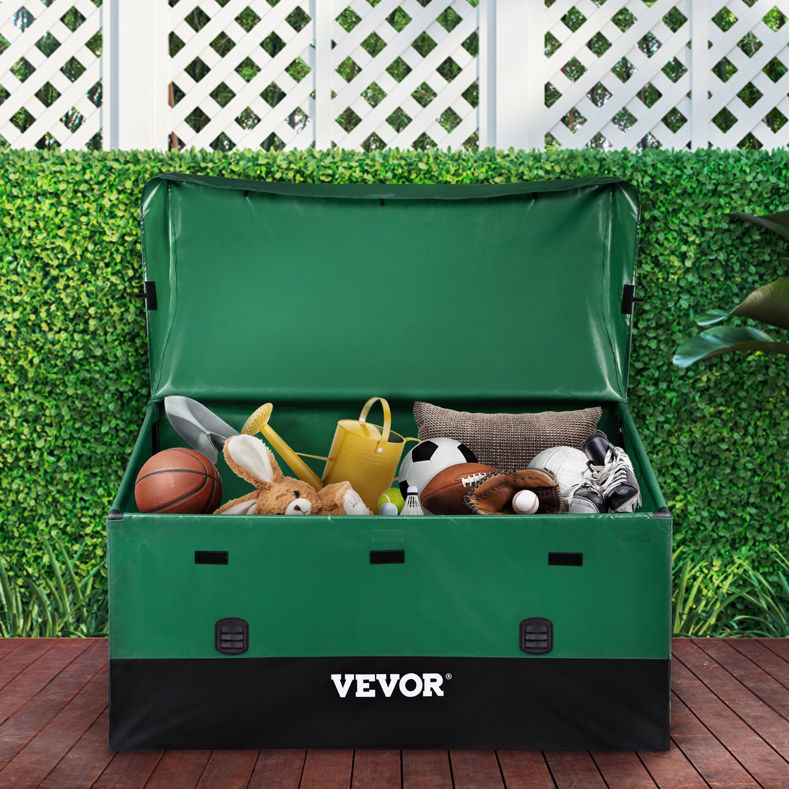 VEVOR outdoor storage box filled with sports equipment and gardening tools on a wooden deck, green hedge background.