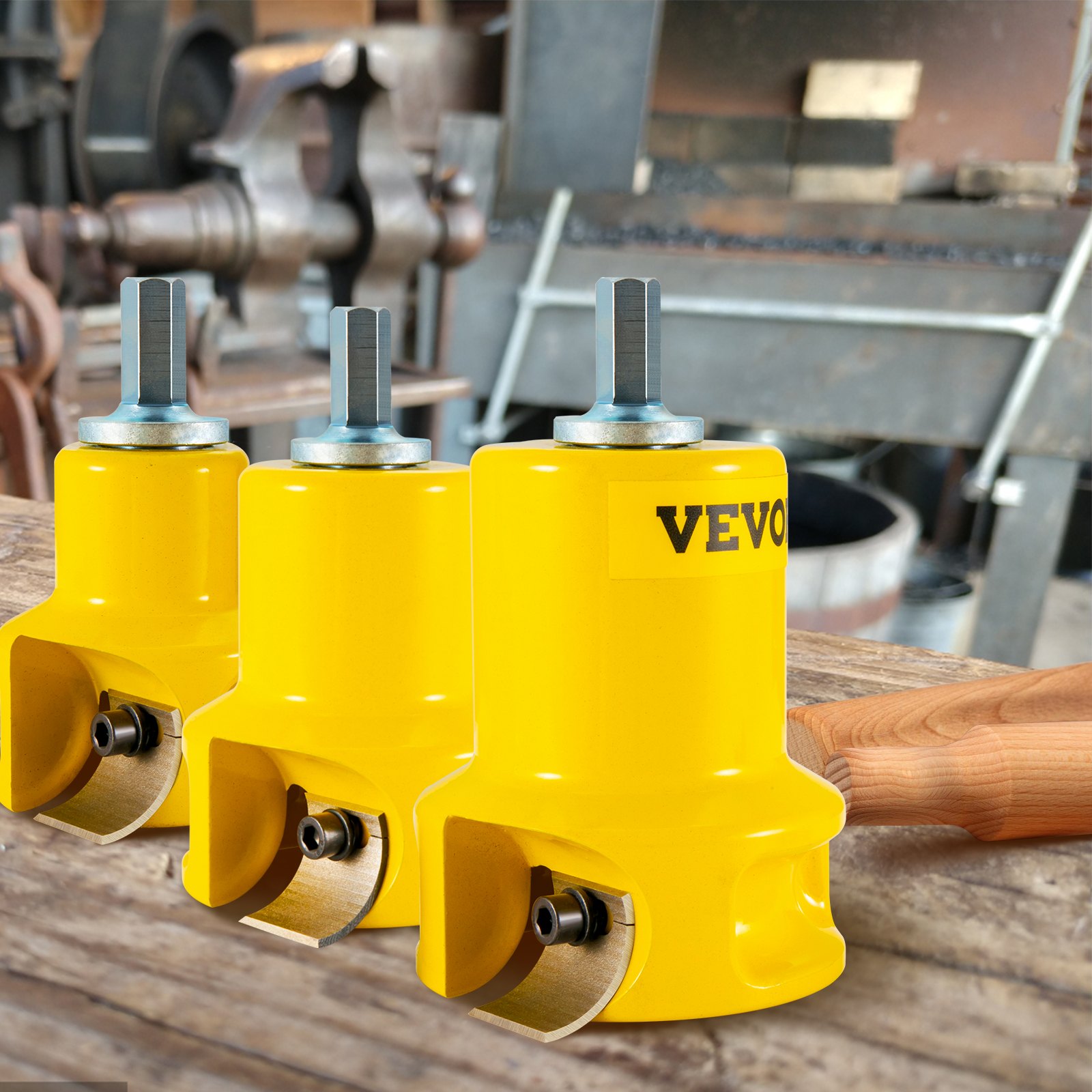 three yellow VEVOR tenon cutters on a workbench, with industrial equipment in the background.
