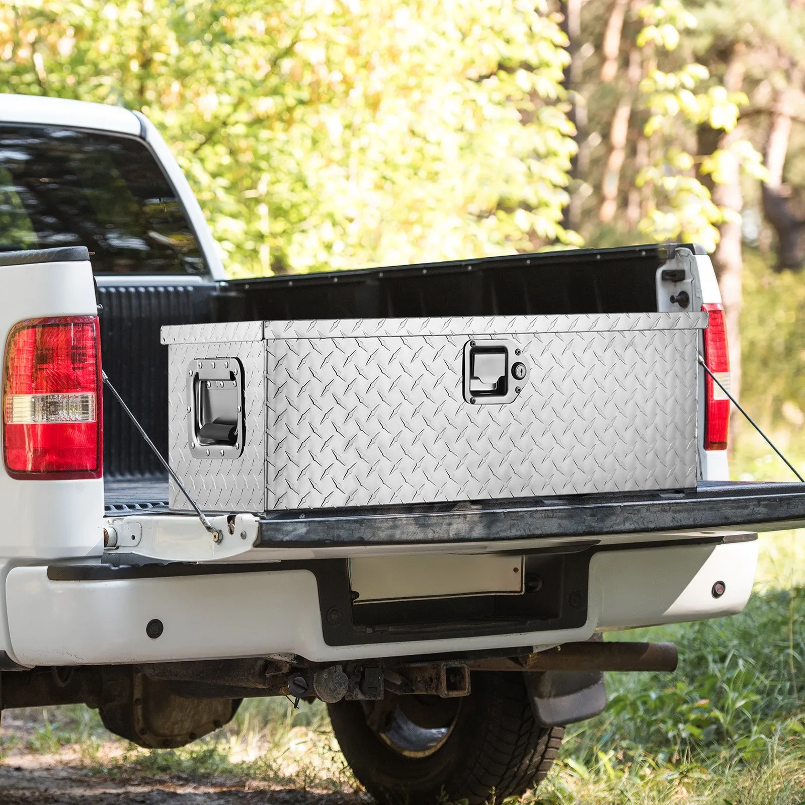 white truck with an open bed featuring a VEVOR aluminum truck bed tool box on a sunny day.