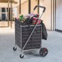 VEVOR folding shopping cart filled with groceries, parked near a modern building entrance.