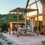 backyard family gathering under a VEVOR pergola bracket kit with string lights and a barbecue smoker.