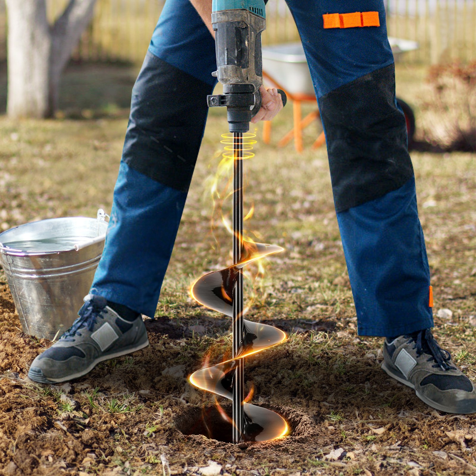 person using a power tool to drill a hole in the ground with VEVOR auger drill bits.