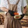 person in brown overalls holding VEVOR chainsaw sharpener in a forest with logs in the background.
