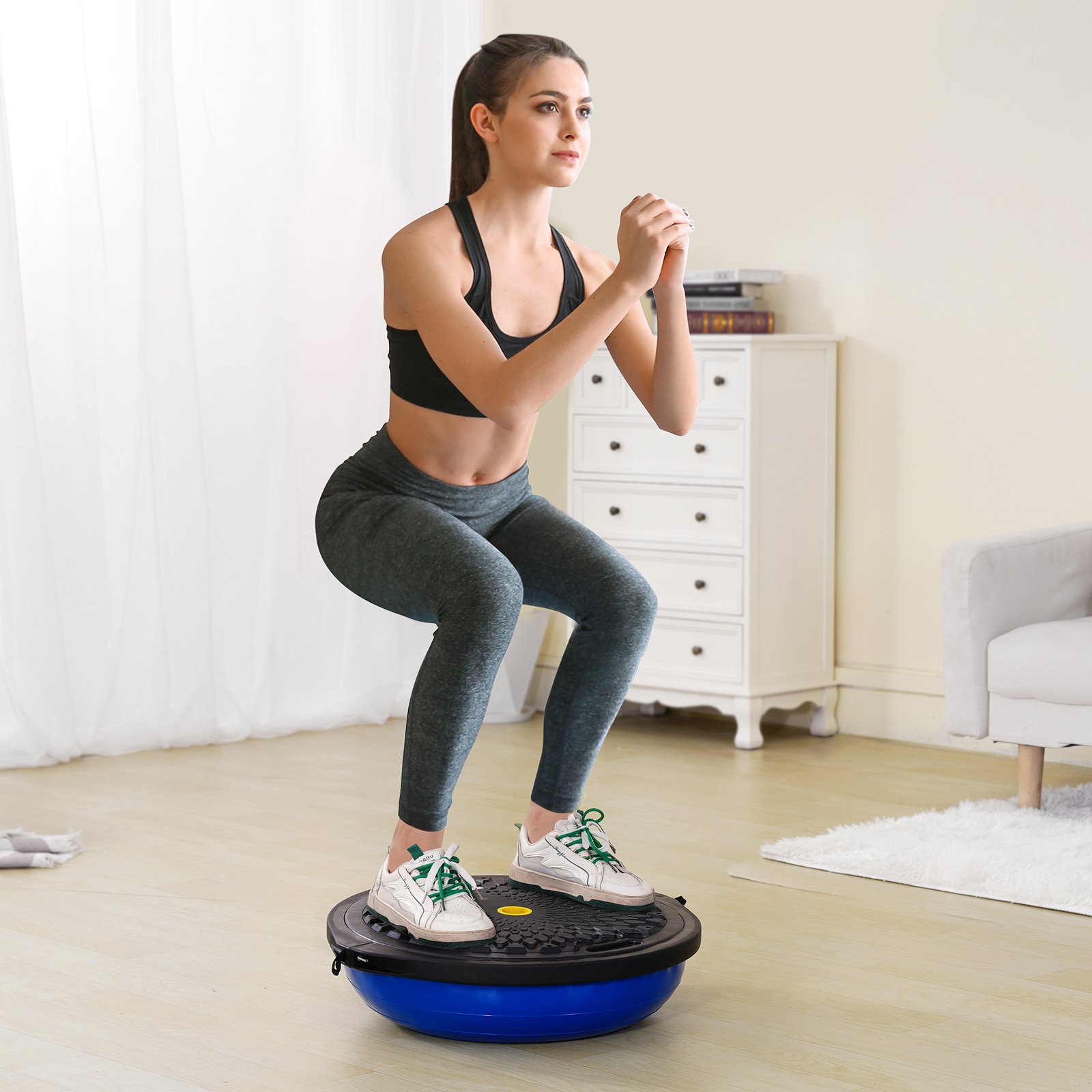 woman doing squat exercise on VEVOR balance ball trainer in a home workout space.