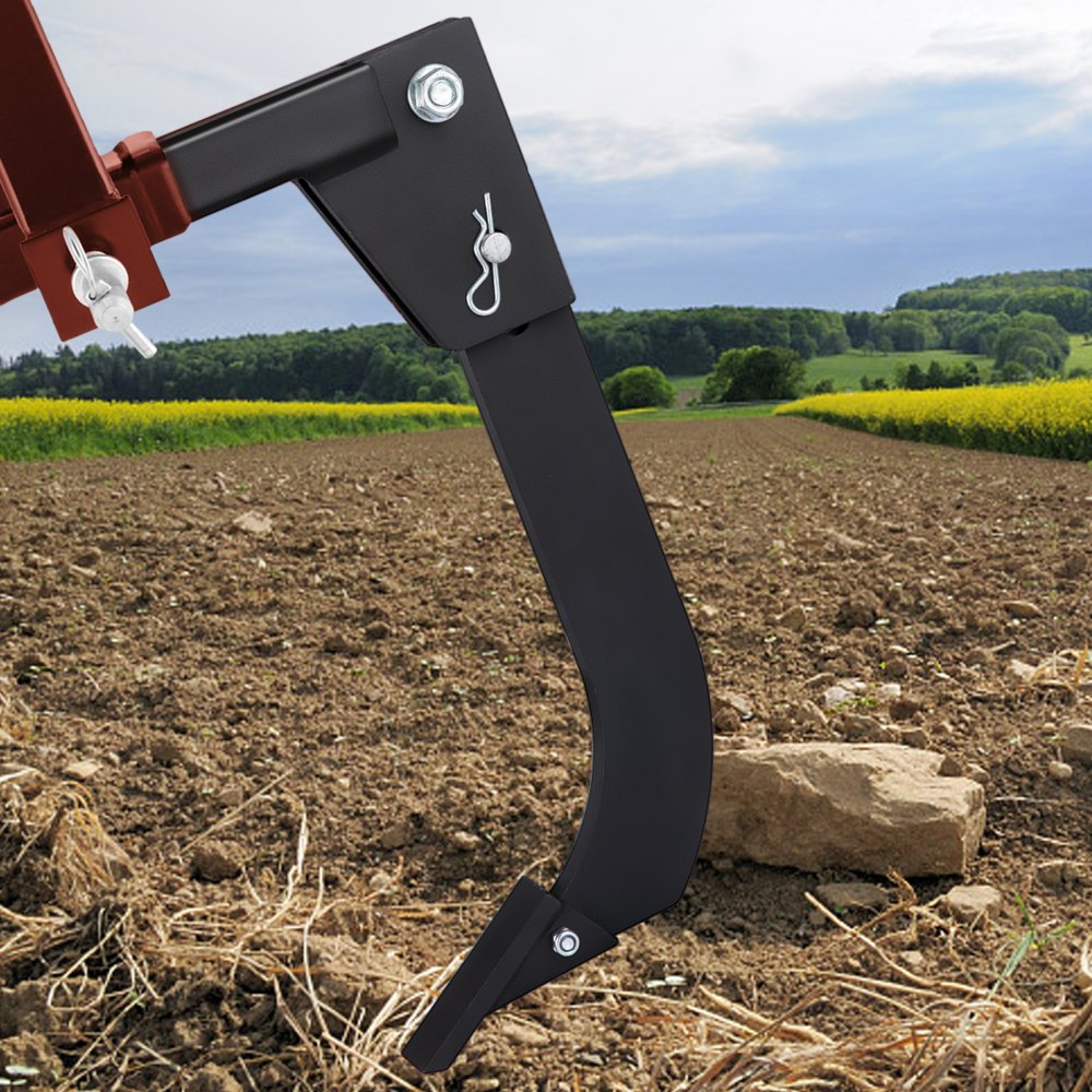 VEVOR hitch mounted ripper working on a plowed field with hills in the background.